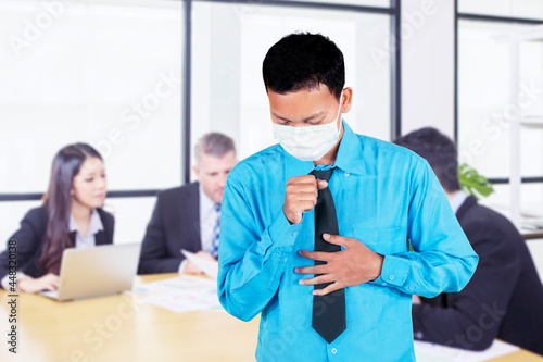 Sick businessman coughing in the meeting room