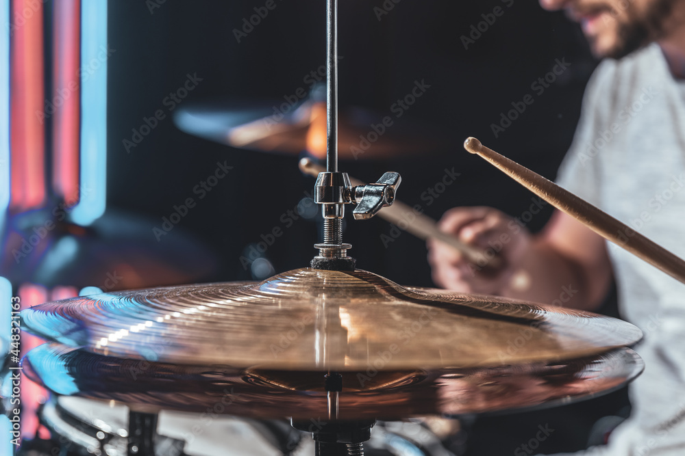 Naklejka premium A male drummer plays drums with special drum sticks.