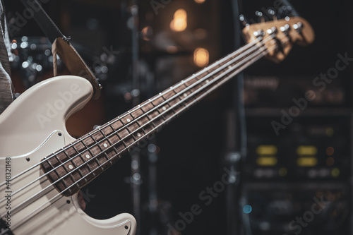 Close up of bass guitar on blurred dark background copy space.