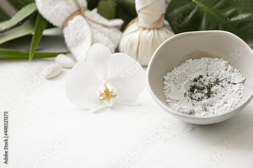 Spa composition with powder face mask and flowers.