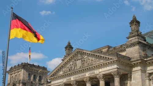 Reichstag Bundestag Berlin Deutschland Germany with german flag on a sunny day summer sky medium shot colorful photo