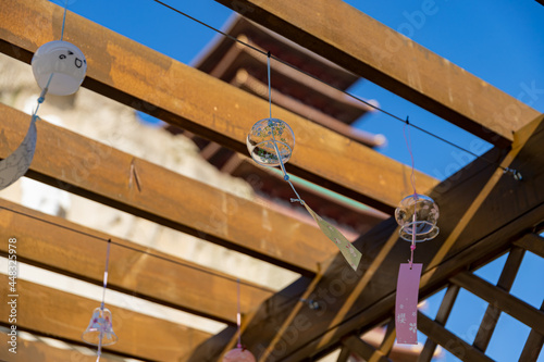 Tablou pe pânză Wind chimes chiming in front of a tower
