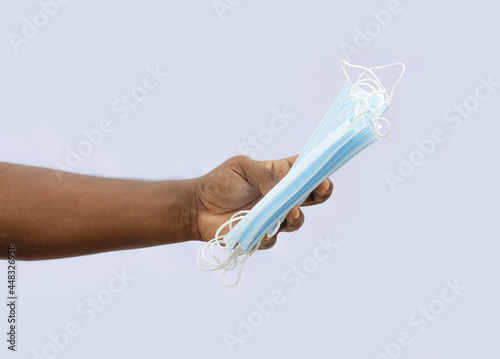 Surgical face masks holding with a male hand on isolated background