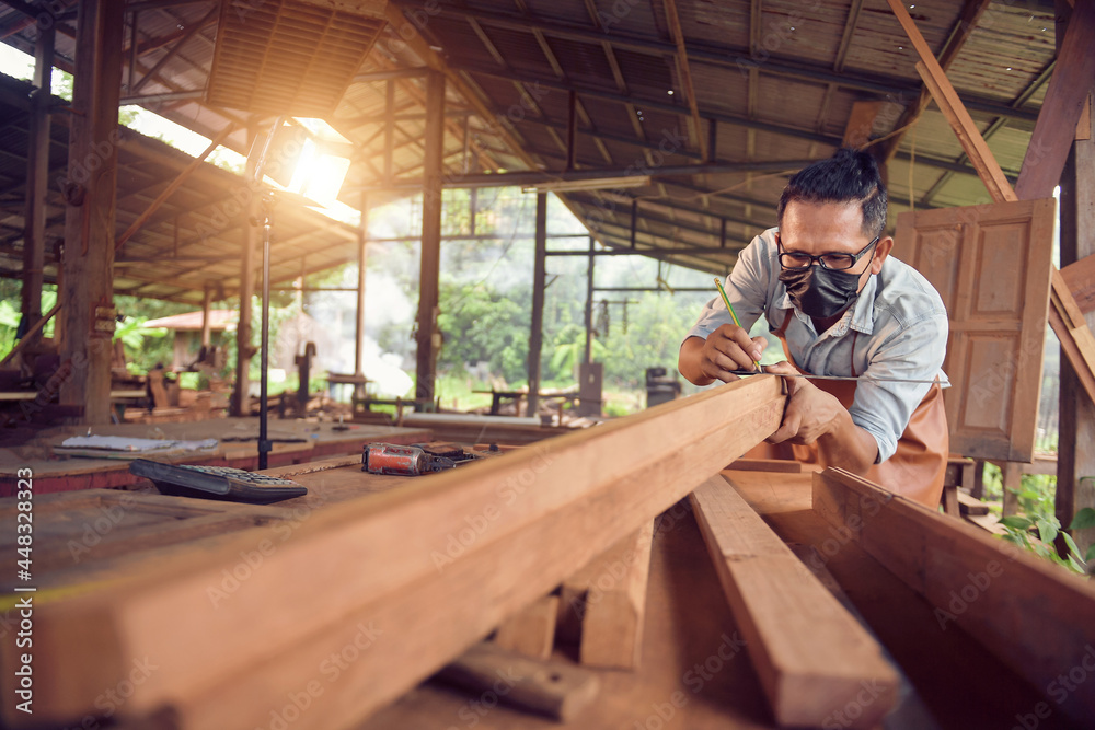 Closeup of a man carpenter using a nail gun.Carpenter using air nail gun doing wooden furniture work