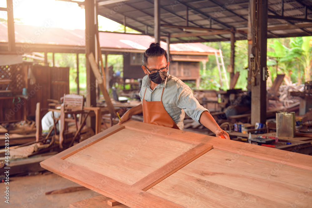 Man doing woodwork in carpentry. Carpenter work on wood plank in workshop Man doing woodwork in carpentry. Carpenter work on wood plank in workshop
