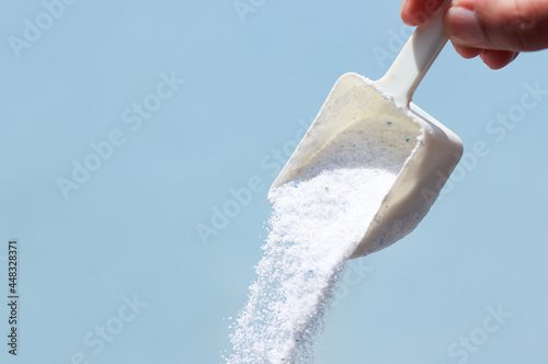 An image pouring detergent for washing powder in the spoon handhold is and comfort cleanliness laundered sell domestic with copy space for text. photo