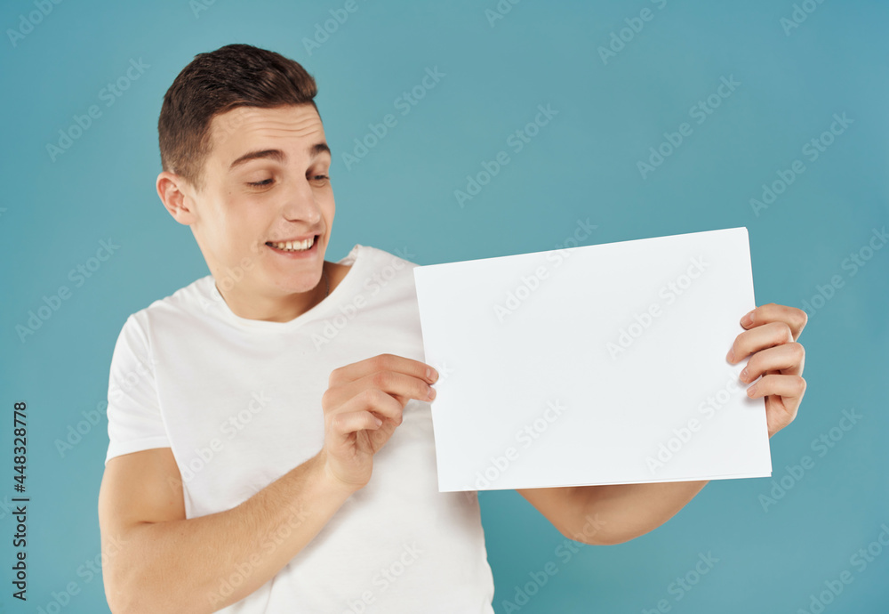 Cheerful man with a sheet of paper in his hands Copy Space emotions blue background Cheerful man with a sheet of paper in his hands Copy Space emotions blue background