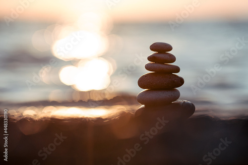 Pyramid of stones on the beach at sunset  beautiful seascape  rest and seaside vacation concept. 