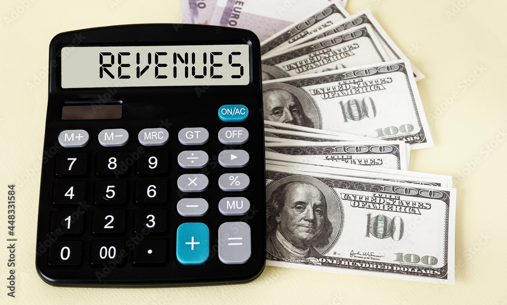 Calculator with the word REVENUES on display with dollars on a white background. Calculator with the word REVENUES on display with dollars on a white background.