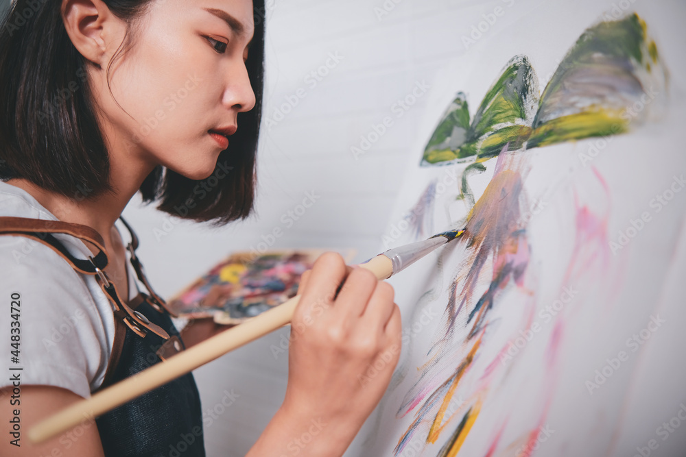 Asian woman artist painting picture with blank canvas side view, using paint brush and colour pallets having fun creativity activity occupation hobby concept, creative thinking imagination visual - obrazy, fototapety, plakaty 