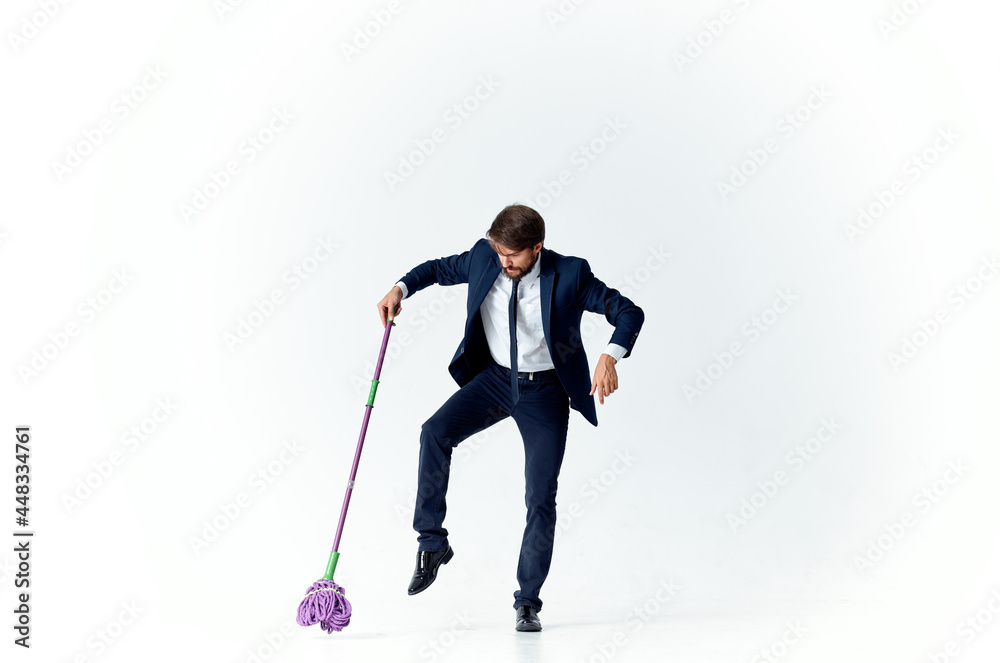 Fototapeta premium business man in a suit with a mop in his hands providing services cleaning floors