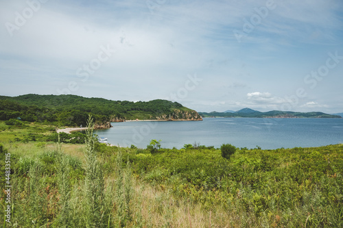 summer azure clear sea panorama. shallow transparent sea with reefs, rocks and green hills around. Japan sea. Primorsky Krai in Russia, Putyatina Island photo