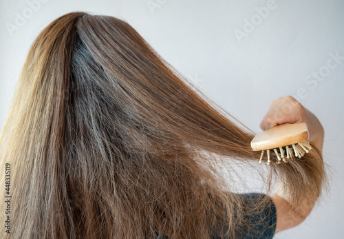 Schilderij op canvas Rear view of young Asian woman brushing her thick hair