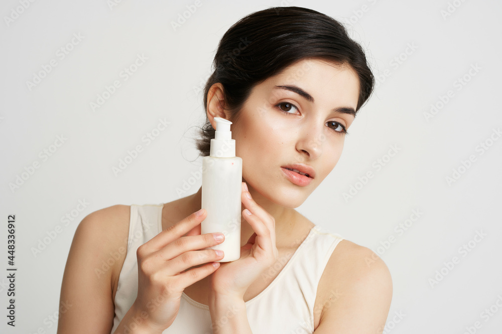 woman holding near face lotion close-up clean skin woman holding near face lotion close-up clean skin