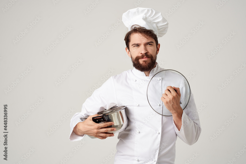 Cheerful male chef with a pan in the hands of a professional cooking food Cheerful male chef with a pan in the hands of a professional cooking food
