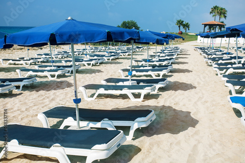 Beach umbrellas and sunbeds at the closing or start of the season. Tourism concept.