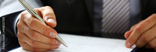 Male arm in suit and tie fill form clipped to pad