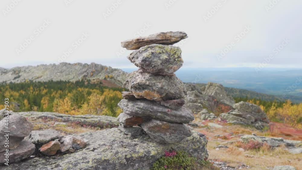 Balanced Rock Stones Stacked on Top of Each Other in the Mountain Valley. Hierarchy and Balance. Pyramid of Stones on the Textured Sky and Beautiful Hills, Mountains. Balanced Rock Stones Stacked on Top of Each Other in the Mountain Valley. Hierarchy and Balance. Pyramid of Stones on the Textured Sky and Beautiful Hills, Mountains.