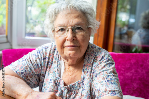 Portrait of a beautiful old woman with gray hair and glasses
