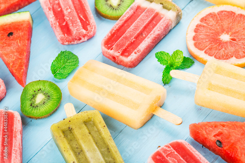 Healthy Whole Fruit Popsicles with Berries Kiwi watermelon cantaloupe on wooden vintage table