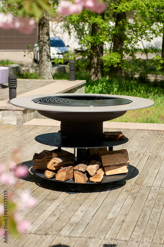 Kettle Grill Pit with Cast Iron Grid with flames . Round table-cooking surface. Hot BBQ on Backyard