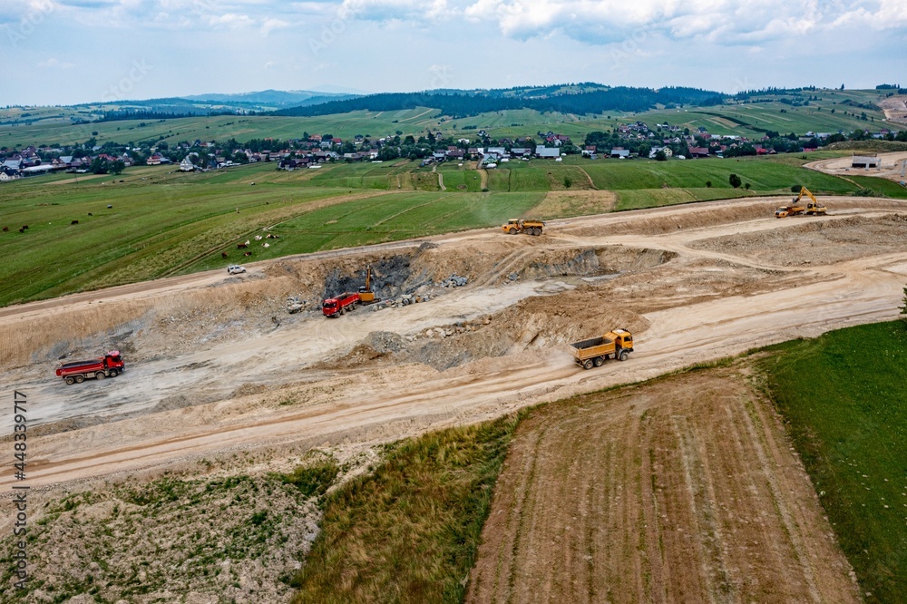 Aerial photo of trucks on a road or highway construction site. Top view of the construction site.