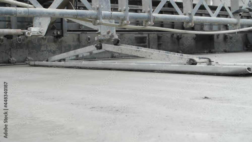 Road paver finisher or paving machine compacting concrete layer, flattening screed or making roadway surface even and smooth. Concept of heavy construction equipment executing motorway compaction.