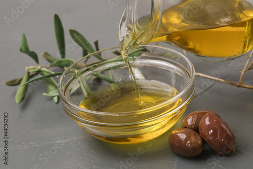Woman pouring extra virgin olive oil in a bowl. Traditional Mediterranean homemade oil.