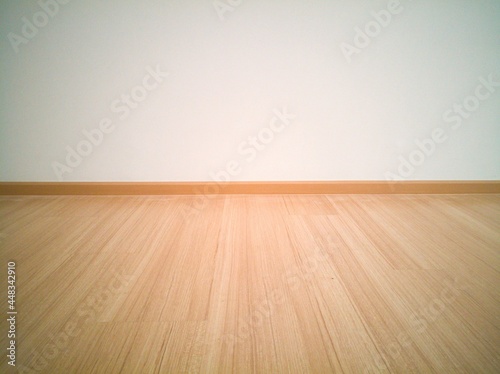 laminate flooring with white wall in empty room.
