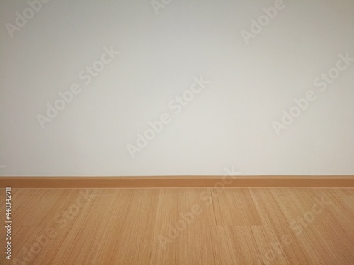laminate flooring with white wall in empty room. © Uthawee