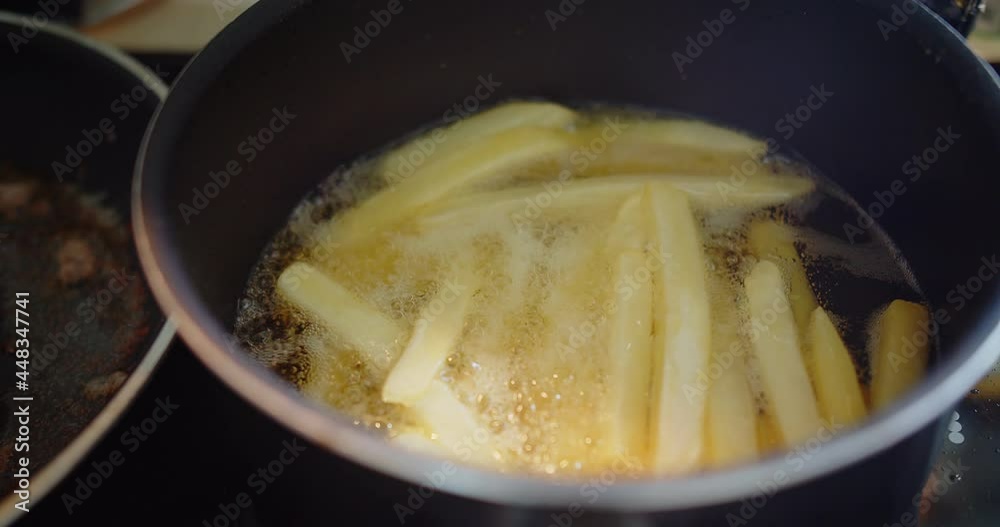 close-up cooking homemade deep frying yellow French fries potatoes in hot boiling splash oil at the kitchen, Fry delicious snack, fast food close-up cooking homemade deep frying yellow French fries potatoes in hot boiling splash oil at the kitchen, Fry delicious snack, fast food