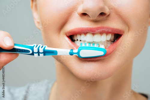 Woman with healthy white teeth holds a toothbrush and smiles. Oral, hygiene concept