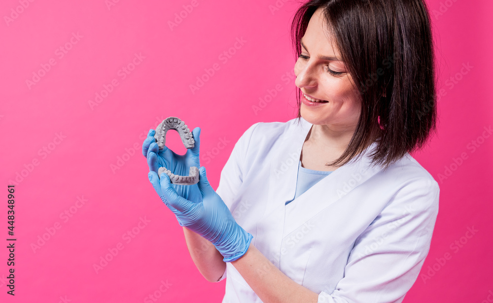 Woman dentist holds in hands dental gypsum models Woman dentist holds in hands dental gypsum models
