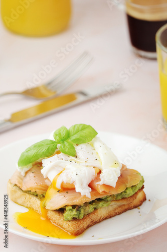 Breakfast with a sandwich with poached egg and avocado 