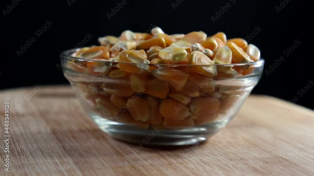 Corn seeds on the glass bowl with black and woooden table background in Brazil Corn seeds on the glass bowl with black and woooden table background in Brazil