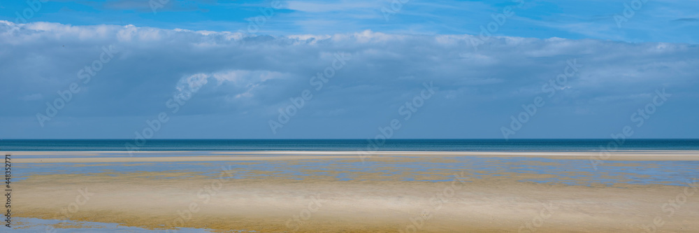 Abstract topography of dramatic sky, calm sea, and clean beach on Cape Cod. Tranquil seascape at low tide over Mayflower Beach in Dennis on Cape Cod. 