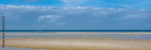 Abstract topography of dramatic sky, calm sea, and clean beach on Cape Cod. Tranquil seascape at low tide over Mayflower Beach in Dennis on Cape Cod. 