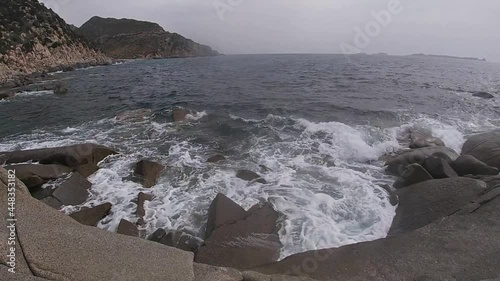 Bad weather on the coasts with strong wind and waves crashing on the rocks