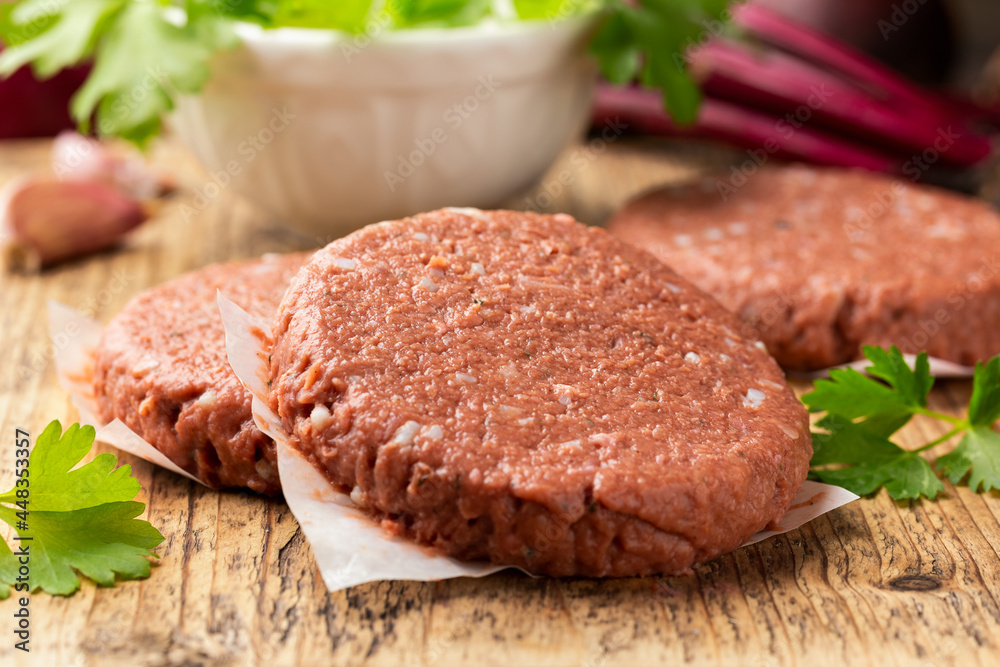 Raw Vegan meat free cutlets, burger on wooden board. ready to cook Raw Vegan meat free cutlets, burger on wooden board. ready to cook