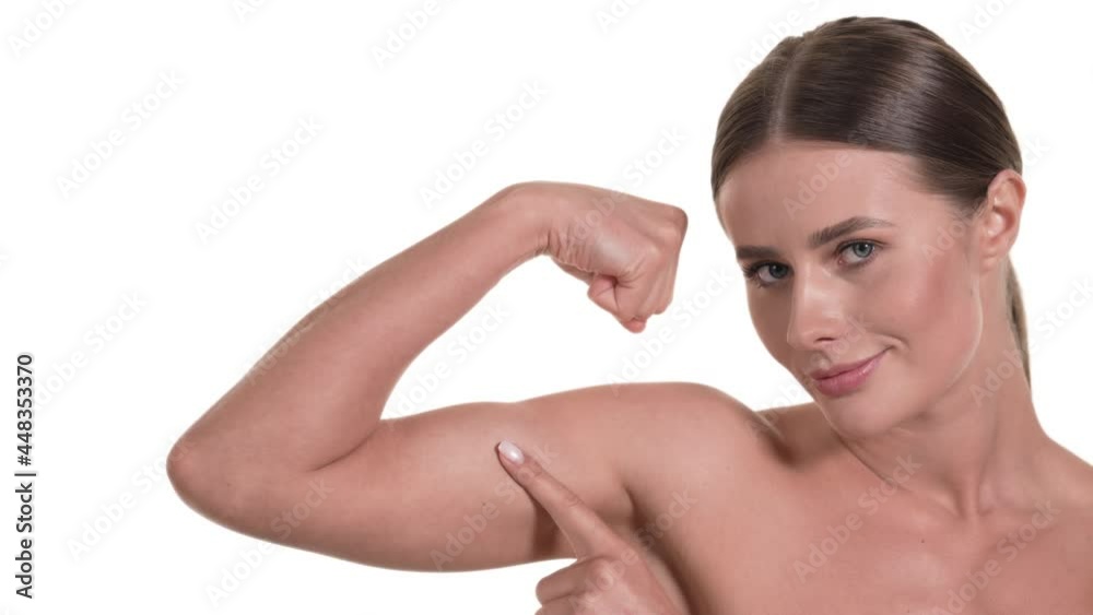 Portrait of a caucasian woman, flexing her biceps, tapping it and smiling. Health concept, white background. Portrait of a caucasian woman, flexing her biceps, tapping it and smiling. Health concept, white background.