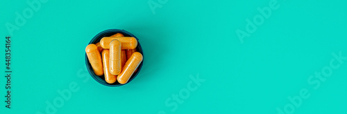 b-complex multivitamin supplement capsules on turquoise background. dietary supplement top view banner. mental wellbeing and personal health concept copy space photo