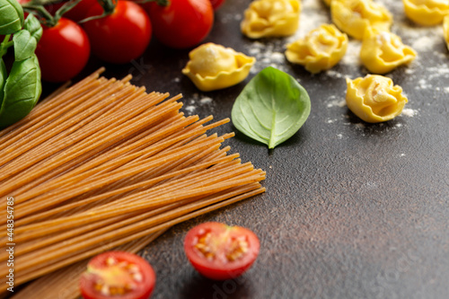 Italian healthy food ingredients ready for cooking. Ravioli, spaghetti, cherry tomatoes, basil