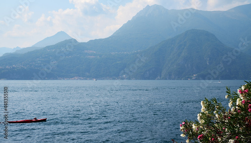 Panorama of Varenna on Lake Como with green hills and mountains on the background.