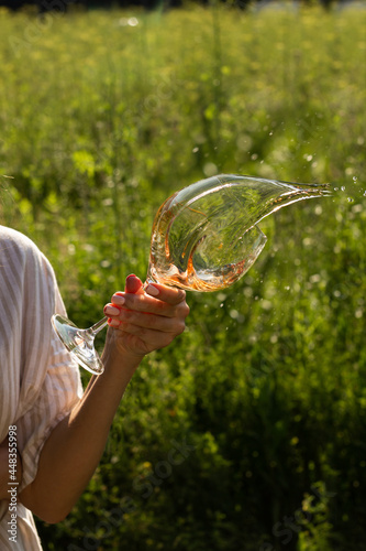 Woman holding a wine glass in a summer park