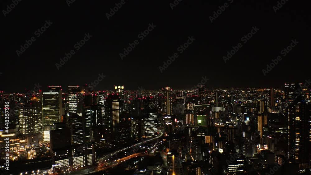 UMEDA, OSAKA, JAPAN : Aerial high angle view of CITYSCAPE of OSAKA at night. View of buildings and street around Osaka and Umeda station. Wide view real time shot. UMEDA, OSAKA, JAPAN : Aerial high angle view of CITYSCAPE of OSAKA at night. View of buildings and street around Osaka and Umeda station. Wide view real time shot.