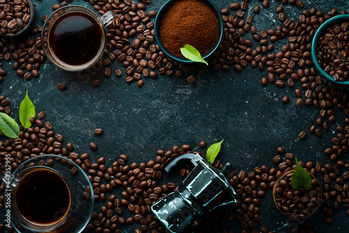 Coffee background. Coffee in cups and coffee beans on a black stone background. Top view. Free space for text.