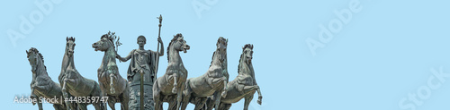 Banner with statue of Goddess Victoria with horses at the top of Triumphal Arch called Arch of Peace in Milan historical downtown  Sempione Park  Italy  at blue sky background with copy space