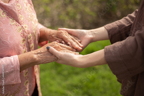 Hand of eldery woman with her caregiver at home. Home care or Elderly care concept.