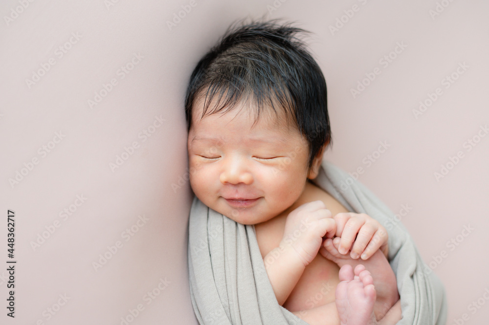 Cute smile baby with beige wrap lying on the blanket. Cute smile baby with beige wrap lying on the blanket.