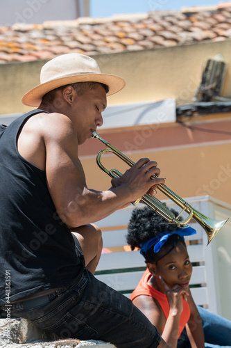 Focused latino man playing a trumpet: Music concept.